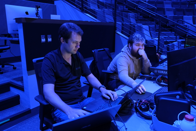 Two people sitting at a video audio station